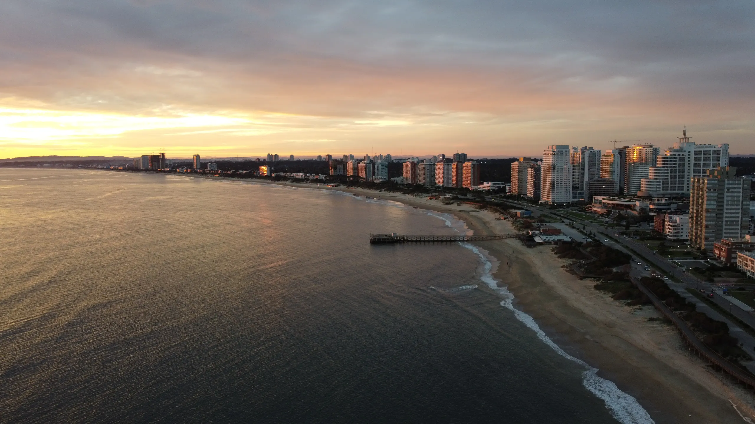La bahía de la Playa Mansa al atardecer, con el muelle y la línea de edificios