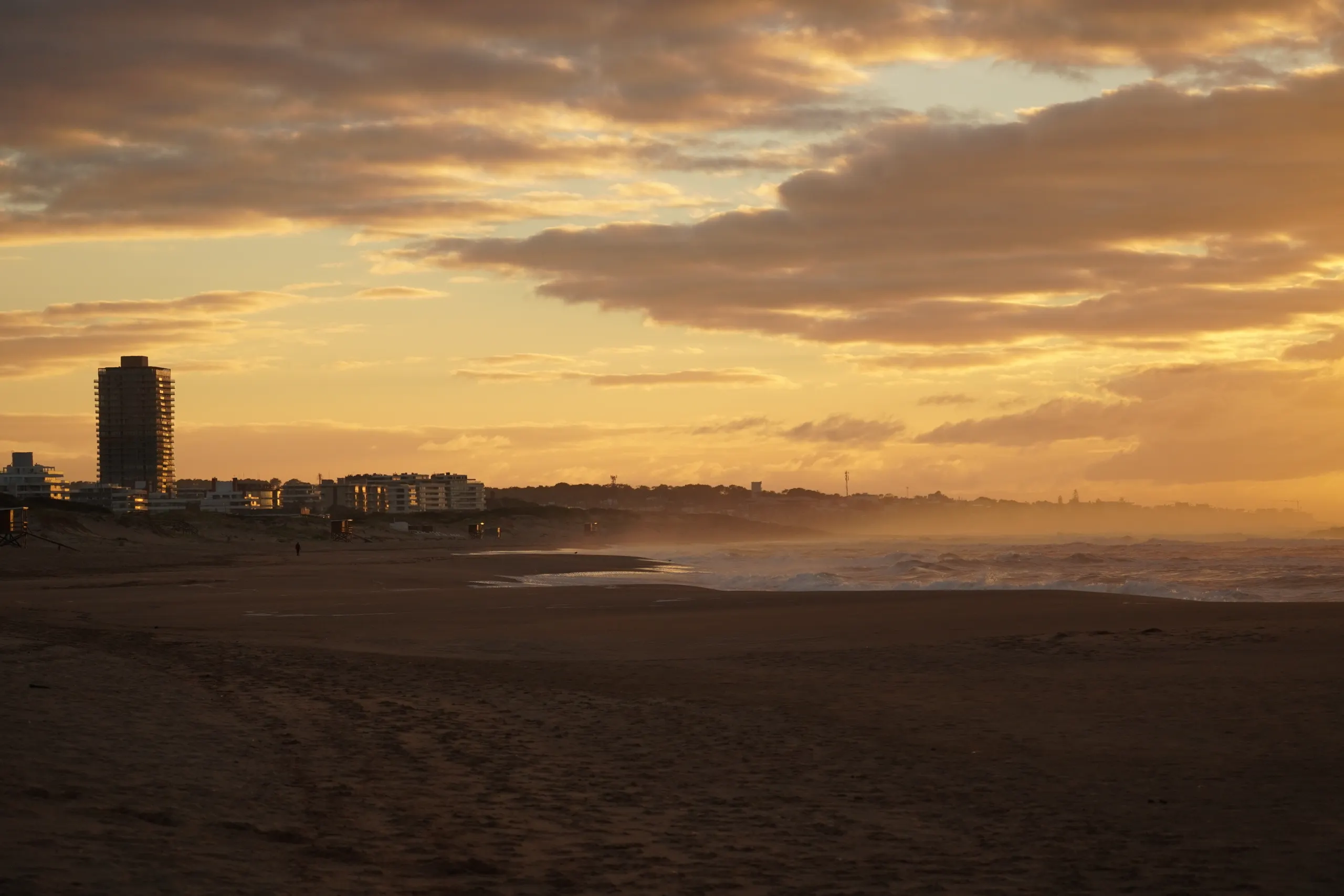 Atardecer sobre la playa de Punta del Este, con la ciudad recortada al fondo
